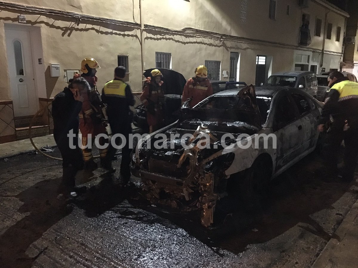 Bomberos y Policia Local ante el vehículo siniestrado la noche del viernes en Buñol.
