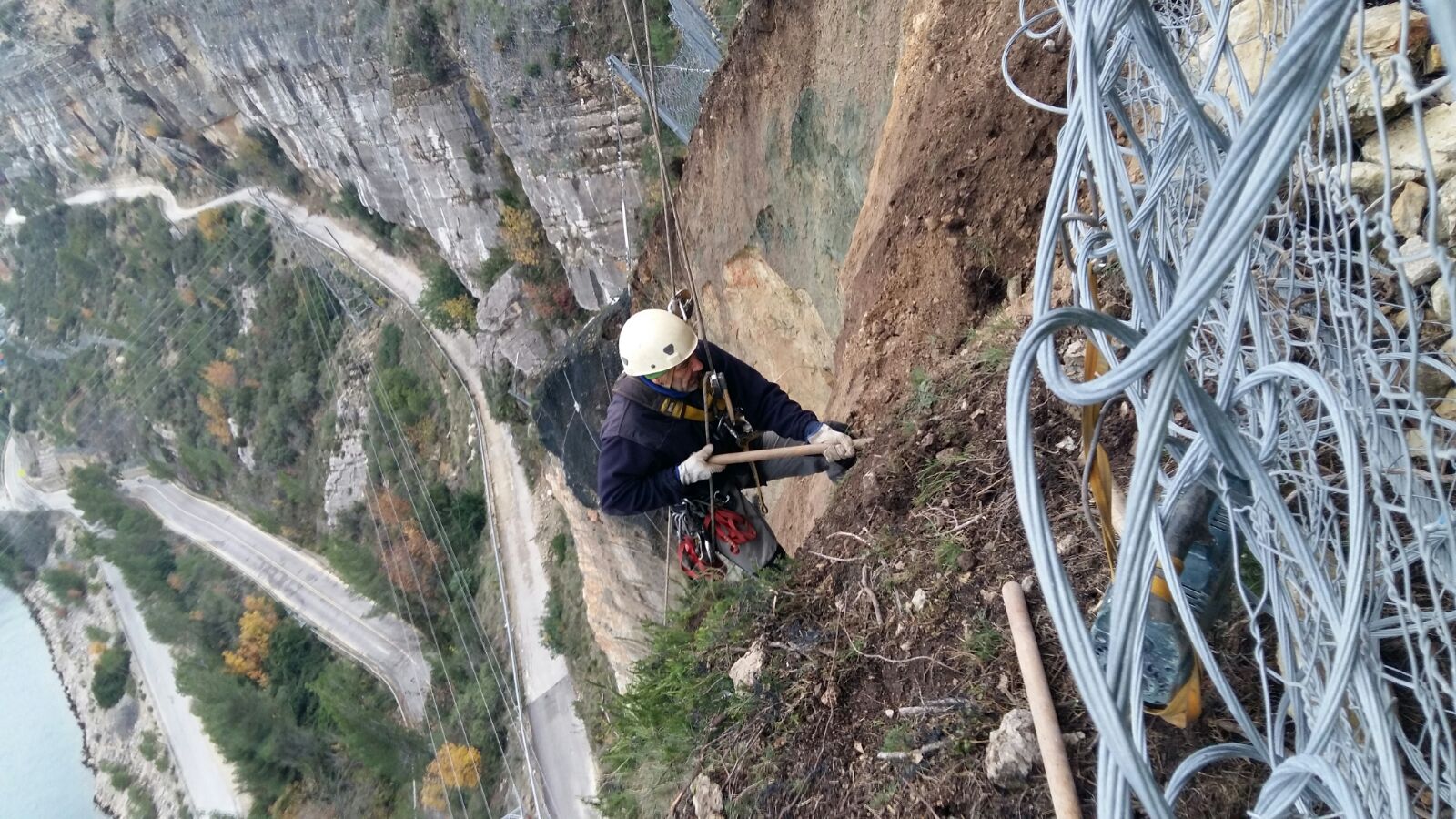 Un operario realiza trabajos de consolidación sobre la carretera afectada de Cortes de Pallás.